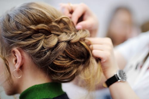 Bridal hair stylist creating elegant updo for wedding in Winnipeg mobile bridal hair services